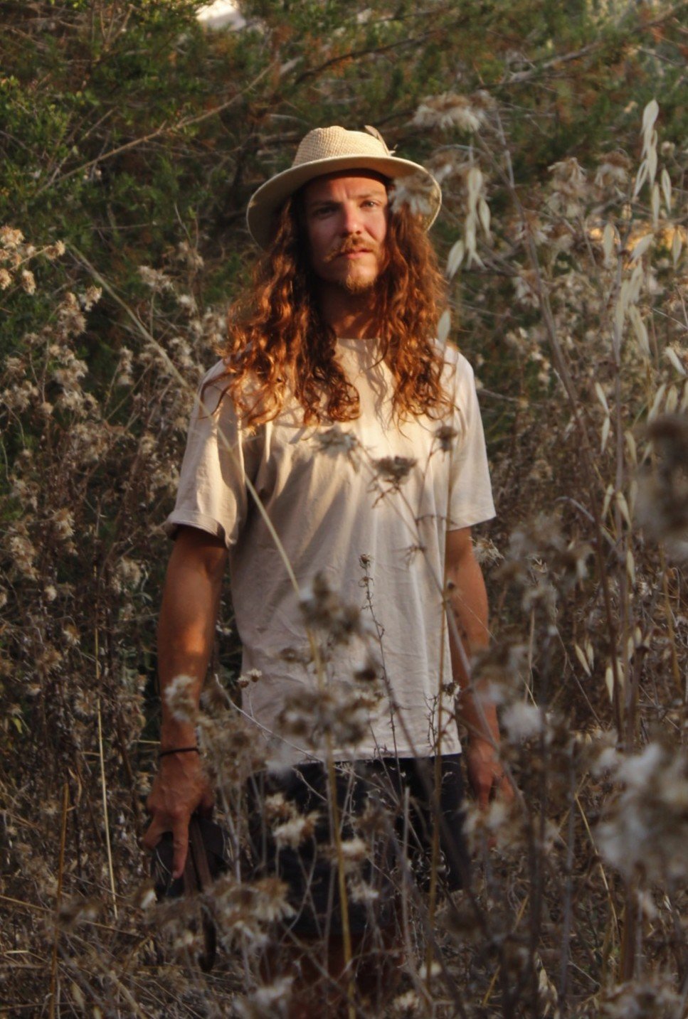 Alessandro Fortunato au milieu de la nature, chapeau de paille et cheveux longs